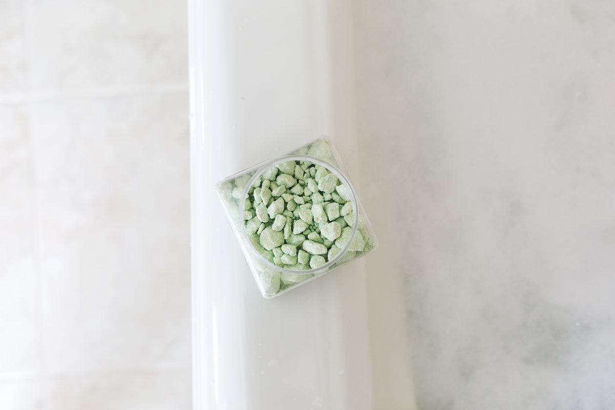 Jar of bath salts on the edge of a bathtub