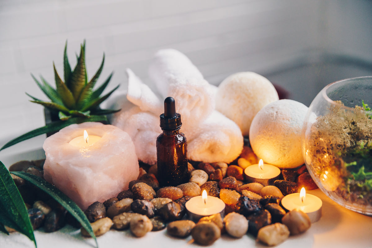 Lit amber oud candles beside spa decor